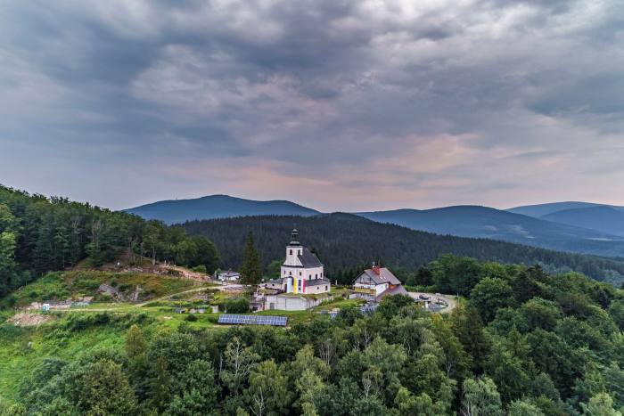 Una chiesa bianca vista dall'alto, immersa nel verde delle colline