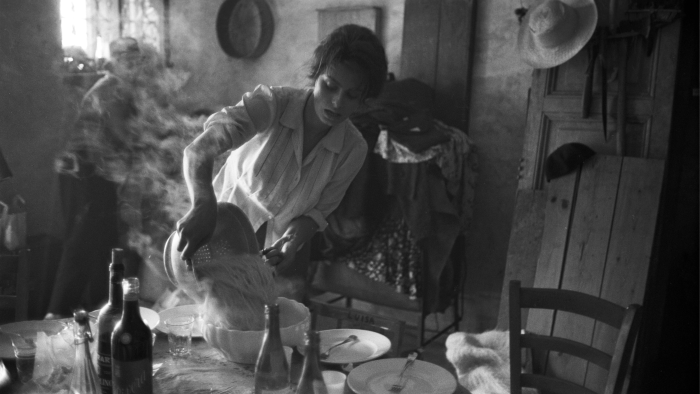Foto in bianco e nero dell'attrice italiana Sophia Loren che scola gli spaghetti