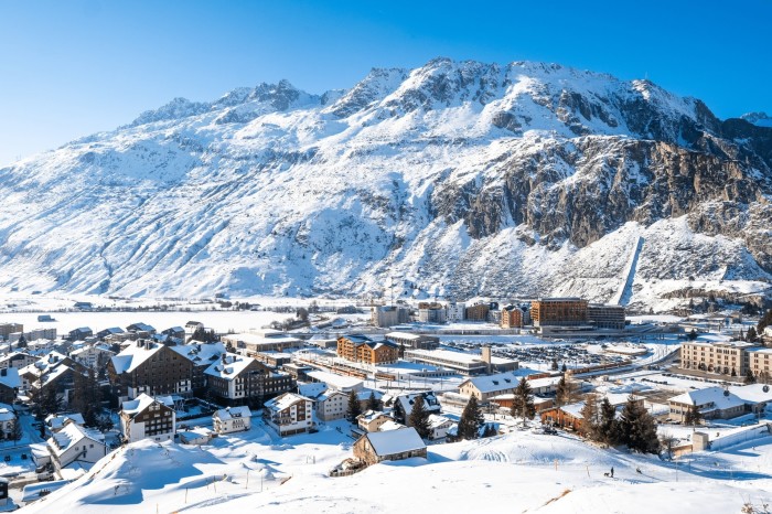 Una fotografia aerea di Andermatt, un tradizionale villaggio alpino svizzero circondato da cime innevate