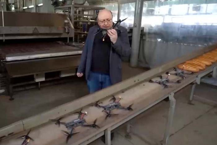 Alexander Rogatkin tiene in mano un drone accanto a una fila di fuchi e pane