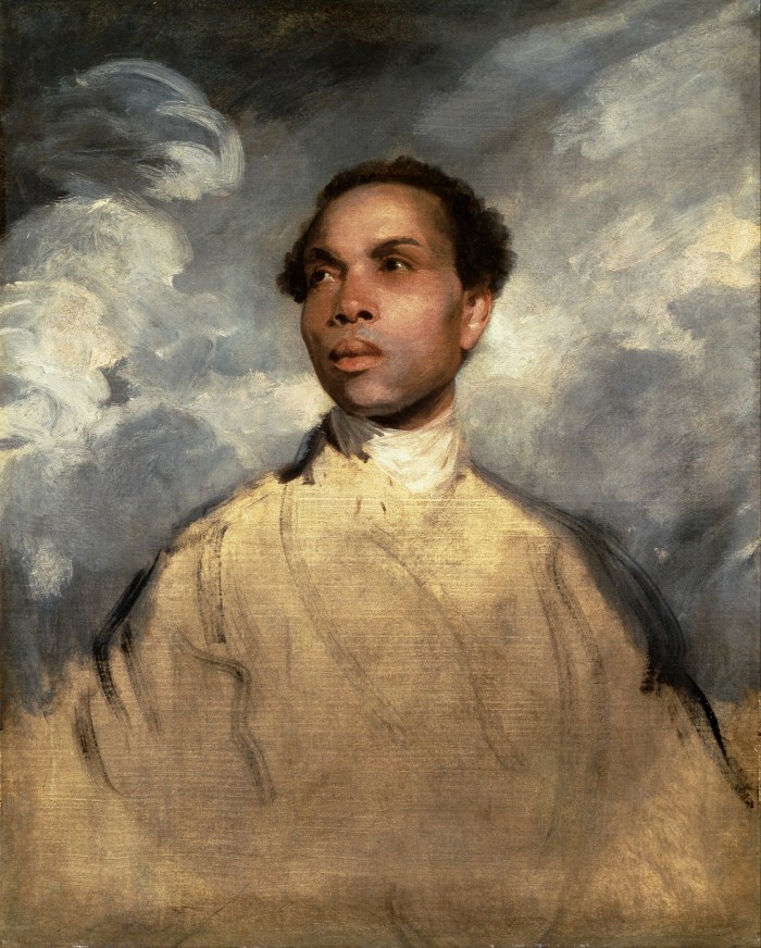 Un giovane alza lo sguardo al cielo. Sullo sfondo ci sono nuvole grigio-bianche