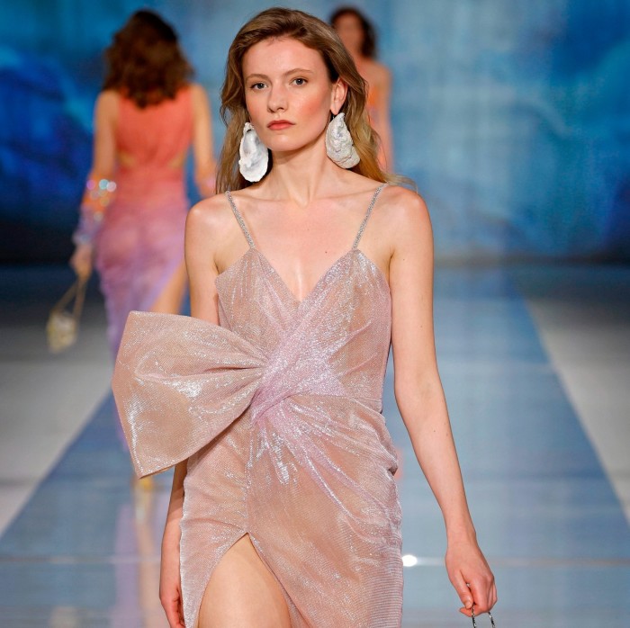 Una donna indossa un abito rosa e vaporoso in passerella