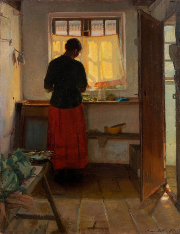 'La cameriera in cucina' di Anna Ancher: una giovane donna che lavora in una cucina davanti a una finestra piena di sole e coperta da tende fragili
