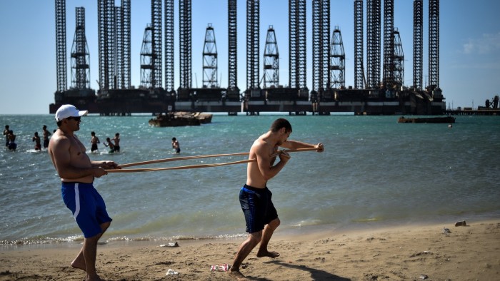 Teenagers from a boxing school take part in a training session on the shores of the Caspian Sea near Soviet oil rigs in the Azerbaijani capital Baku