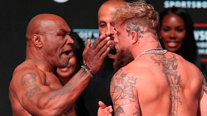Mike Tyson, left, slaps Jake Paul during the weigh-in ahead of their heavyweight bout
