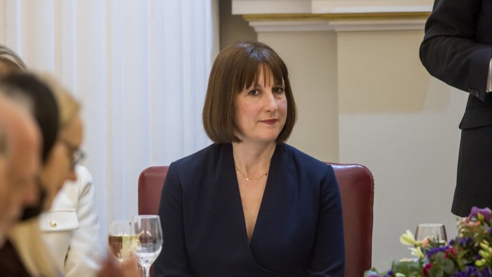 Rachel Reeves sits at a table during her Mansion House speech in London