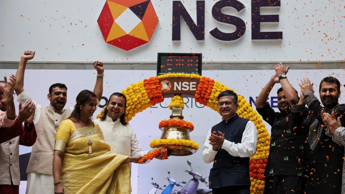 Company officials ring the bell during Ola Electric's listing ceremony at the National Stock Exchange in Mumbai