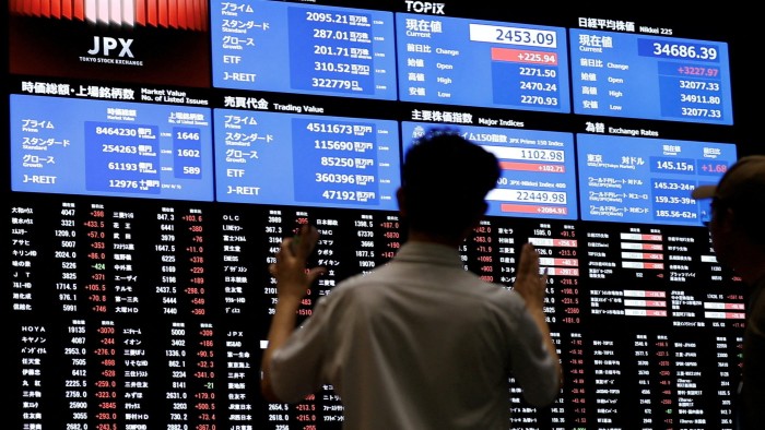 People watching the stock quotation board at the Tokyo Stock Exchange