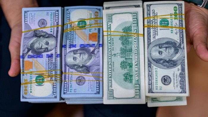 A teller shows US dollar bills