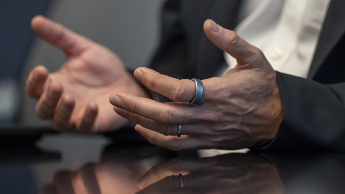 Close-up of two hands with an Oura ring on one finger