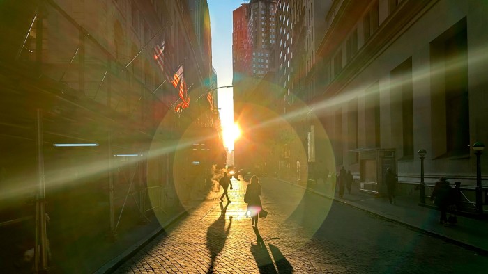 People walk on Wall Street in New York’s financial district