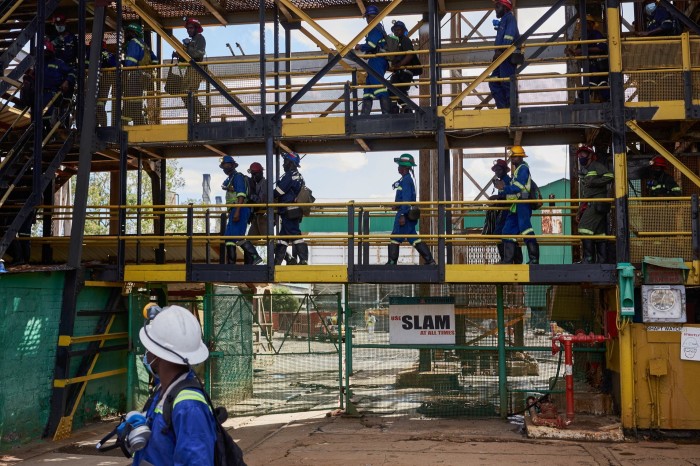 I lavoratori si dirigono verso l'ascensore dell'albero di Henderson nella miniera di Mufulira, gestito da Mopani Copper Mines in Zambia