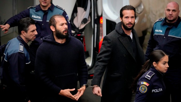 Andrew Tate, centre left, handcuffed to his brother Tristan at an appeals court hearing in the Romanian capital Bucharest in 2023 