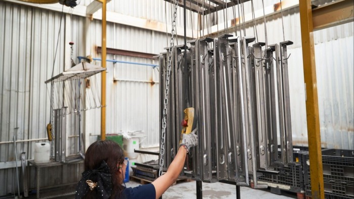 A worker inspects aluminium parts at an auto parts manufacturer in San Luis Potosí, Mexico