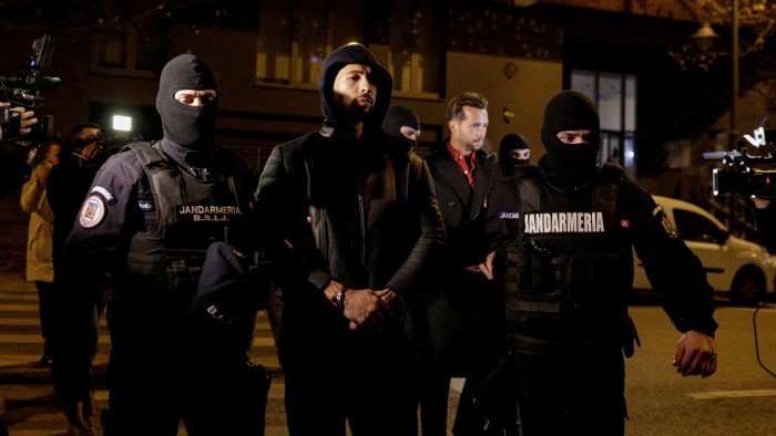 Andrew and Tristan Tate are escorted by police after being detained in Bucharest in December 2022