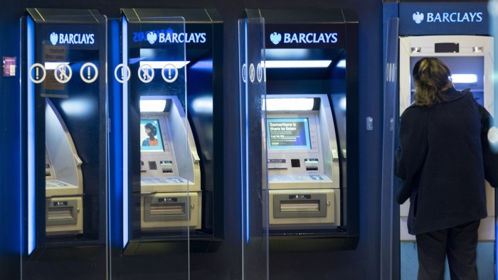 A person stands at one of four Barclays’ ATM machines
