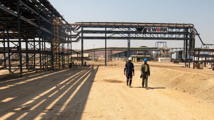 Workers walk at a Glencore facility in Democratic Republic of Congo