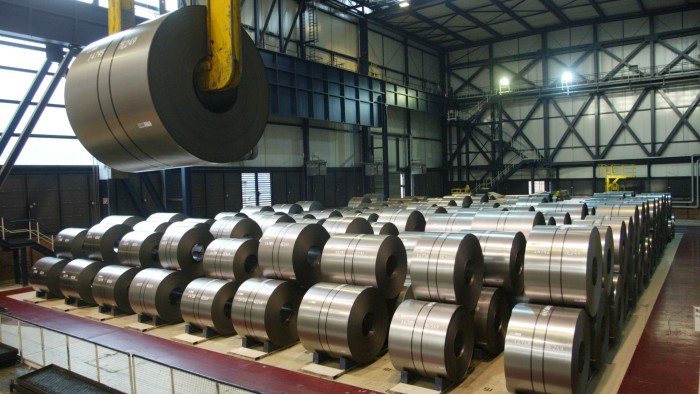 A large industrial lift is moving a giant spool of finished steel inside the Thyssenkrupp steel plant in Duisburg, Germany.