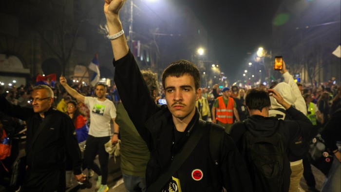 A university student holds his fist high while marching into Belgrade