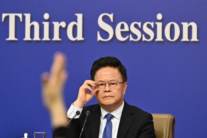 Zheng Shanjie si è seduto in una conferenza stampa con una mano di un giornalista sollevato in primo piano