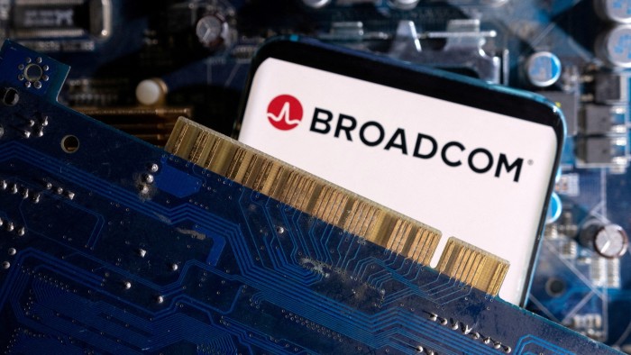 A smartphone displaying the Broadcom logo is placed on a computer motherboard