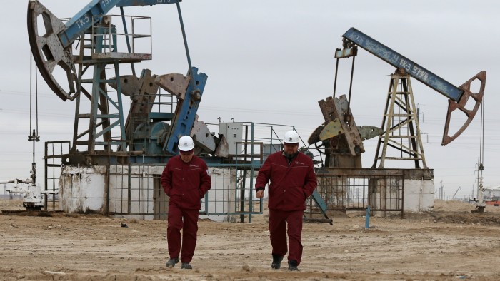 Workers in front of oil pumps in the Mangistau region of Kazakhstan