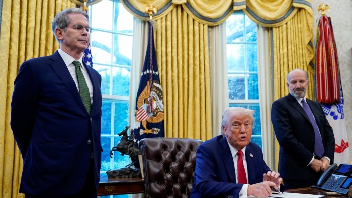 US Treasury secretary Scott Bessent and Howard Lutnick stand either side of President Donald Trump in the Oval Office