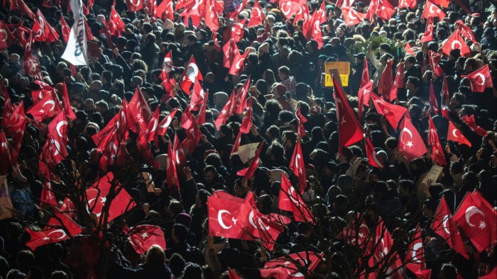 Protesters gather in front of the municipality headquarters in Istanbul, waving Turkish flags and holding signs