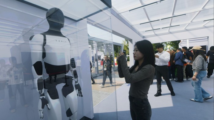 People look at Tesla’s humanoid robot “Optimus