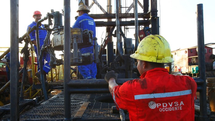 Workers operate flow valves on a PDVSA oil platform