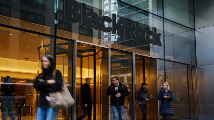People walk in and out of the entrance of BlackRock headquarters in New York City.