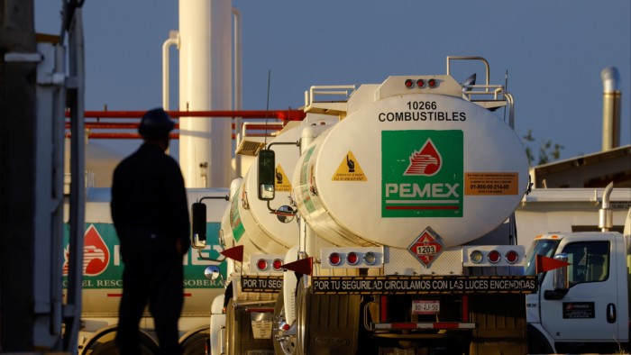A worker stands near a tanker truck at a Petroleos Mexicanos fuel storage and distribution centre
