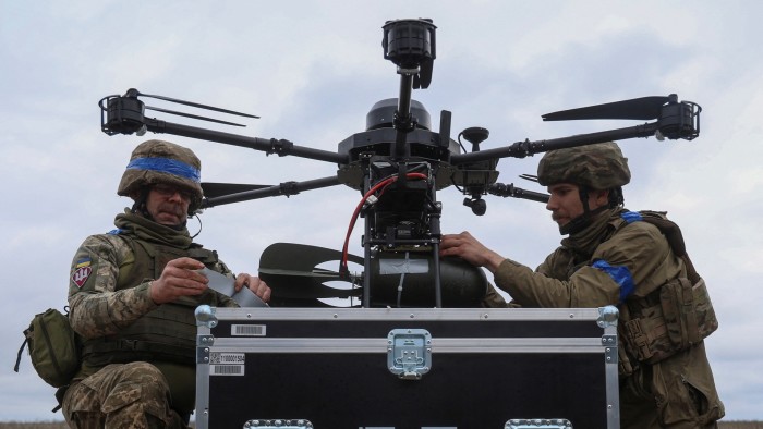 Ukrainian servicemen of the 25th Airborne Brigade attach small air bombs to a Vampire drone