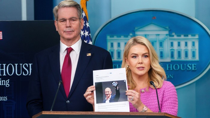 White House press secretary Karoline Leavitt, centre, holds a photograph of Amazon founder Jeff Bezos with Treasury secretary Scott Bessent, left, during a press briefing at the White House in Washington on April 29 2025