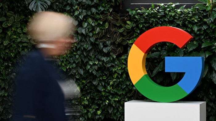 A person walks by Google sign