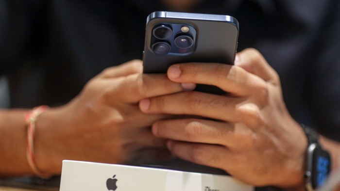 A customer uses an iPhone 15 Pro smartphone at an Apple store