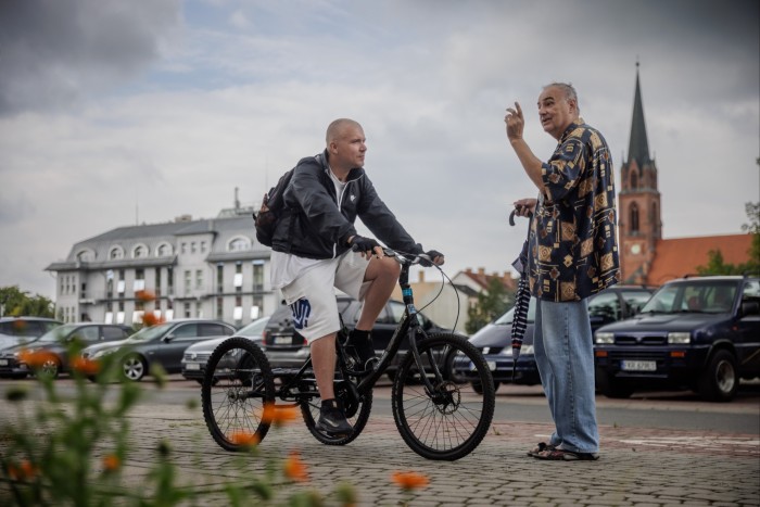 Un uomo su una bici parla con un altro uomo a Gubin, sul lato polacco
