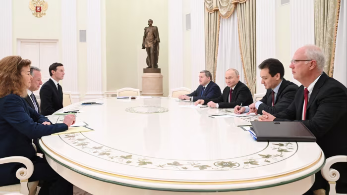 Vladimir Putin, Kirill Dmitriev, Yuri Ushakov, Steve Witkoff and Jared Kushner seated around a large oval table during a meeting at the Kremlin.