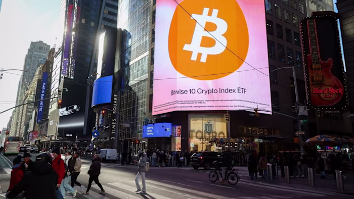 Large digital billboard in Times Square displays a Bitcoin symbol and "Bitwise 10 Crypto Index ETF" above busy street with pedestrians.