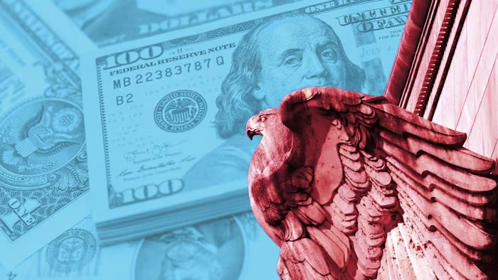 A stone eagle sculpture on the Federal Reserve building is shown against an overlay of US $100 bills.