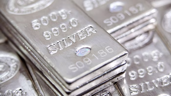 Stacked silver bars marked “500g 999.0 SILVER” are shown close up, highlighting their purity and weight
