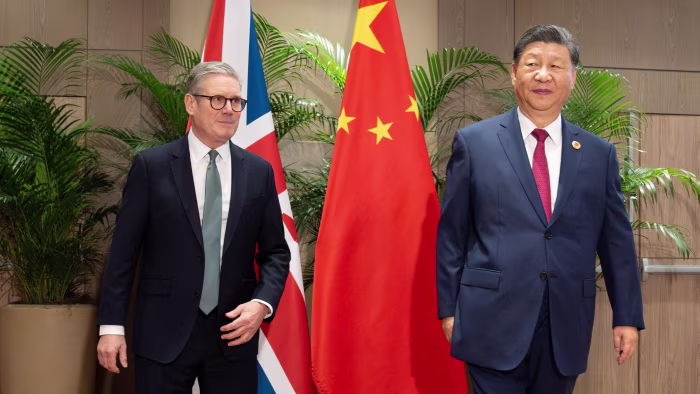 Keir Starmer and Xi Jinping stand in front of UK and Chinese flags during a meeting at the G20 summit.