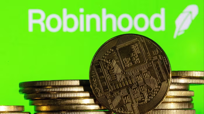A stack of gold-colored coins with a digital circuit design is shown in front of the Robinhood logo on a bright green background.