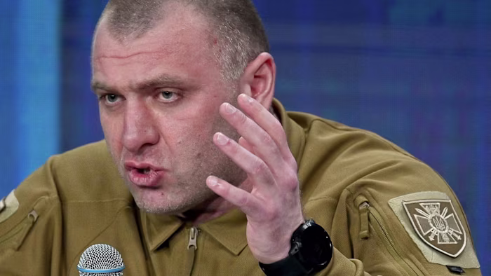 Vasyl Malyuk gestures with his hand while speaking into a microphone at the "Ukraine Year 2024" forum in Kyiv.