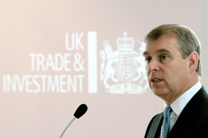 Il principe Andrea parla su un podio con il logo UK Trade & Investment proiettato dietro di lui.