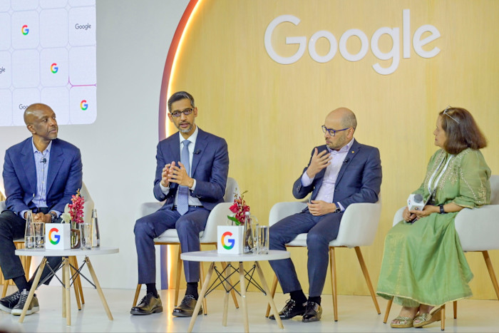 James Manyika, Sundar Pichai, Demis Hassabis e Debjani Ghosh seduti sul palco conversano durante un evento targato Google.