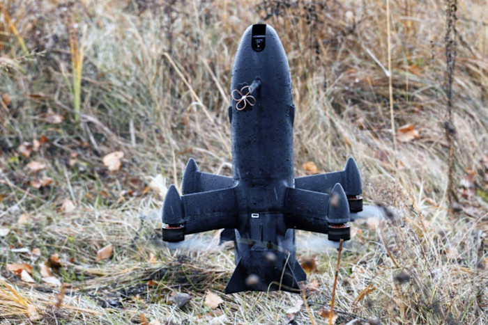 Il drone intercettore americano SkyFall P1-Sun in piedi sull'erba e circondato da vegetazione secca.