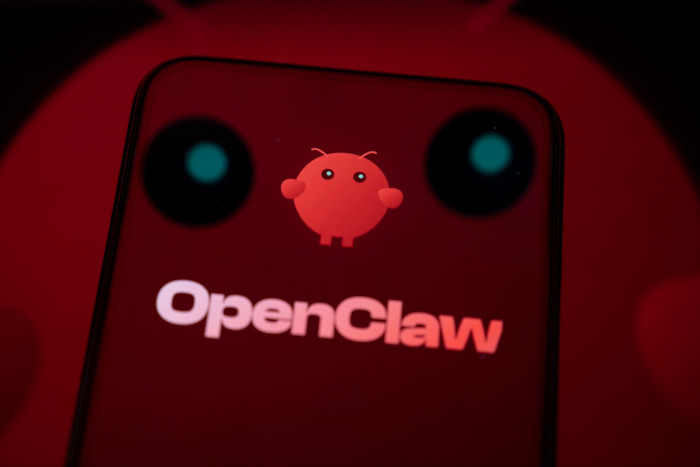 Il logo e la mascotte di OpenClaw vengono visualizzati sullo schermo dello smartphone, con la mascotte proiettata anche sulla superficie riflettente sottostante.